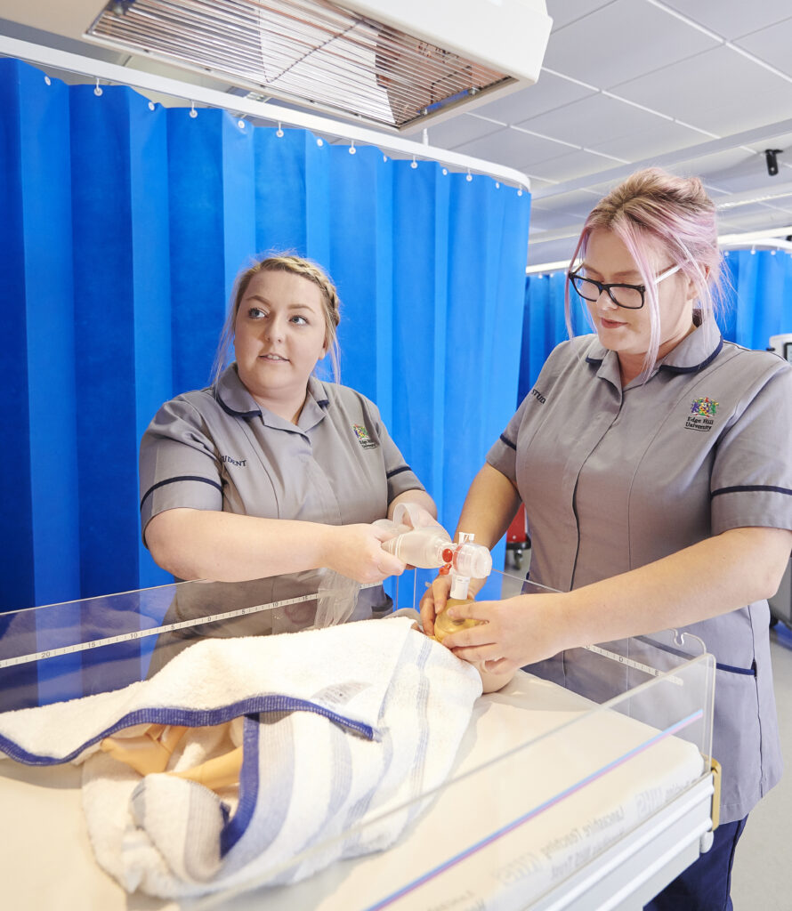 Two nurses training with a baby doll