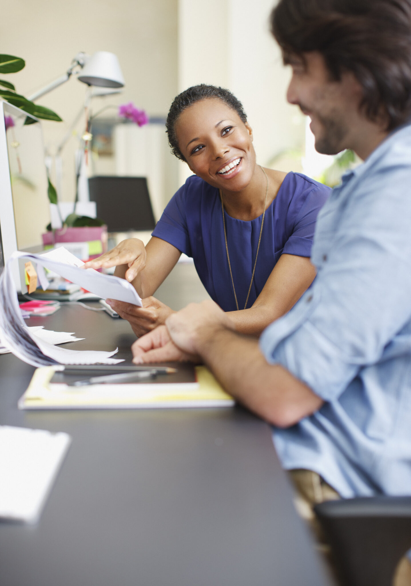 Businessman and businesswoman discussing paperwork in office